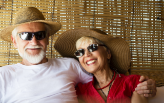 Couple enjoying the sun with protective hat and sunglasses