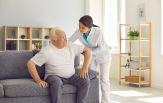 Home health aide helping elderly man
